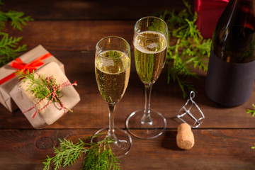 Christmas holiday table with glasses and a bottle of wine of champagne. Eve of new year, preparation and laying of a wooden holiday table