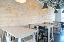 Modern Cafe, Bar Or Club Interior With High Wooden Tables And Chairs