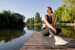 © fotofabrika - Attractive woman practicing yoga on a mat on a pier near the lake in the morning