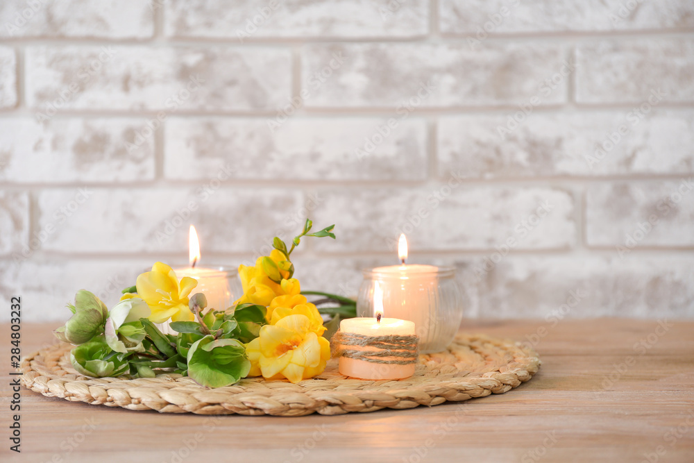 Beautiful burning candles and flowers on table