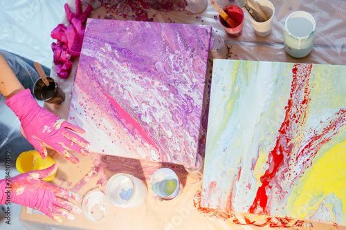 Fotografía Creative woman painter teaching three female student creating fluid acrylic abstract painting in art therapy class, with table full of bottle with defferent paint colors