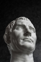 Gypsum Copy Of Ancient Statue Augustus Head On Dark Textured Background. Plaster Sculpture Man Face.