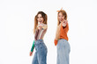 © Drobot Dean - Portrait of two young girls wearing casual clothes smiling and pointing fingers at camera