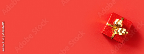 Red gift box on red background.