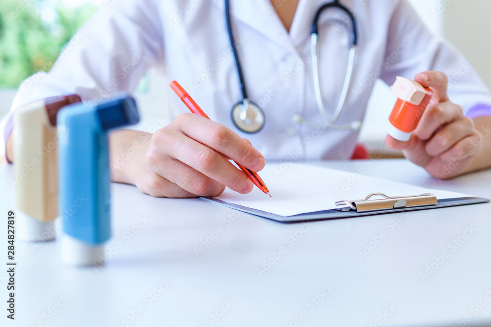 Doctor writes medical prescription for asthma inhaler to asthmatic patient during medical consultation and examination in hospital. Healthcare - obrazy, fototapety, plakaty 