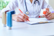 © Goffkein - Doctor writes medical prescription for asthma inhaler to asthmatic patient during medical consultation and examination in hospital. Healthcare