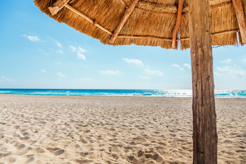 Wall Mural - View on beach under thatched sun umbrella