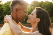 © Drobot Dean - Portrait of happy middle-aged couple looking at each other and hugging while walking in summer park