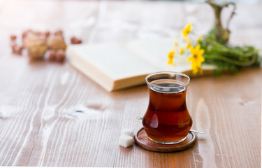 Turkish tea on wooden table, reading book and drinking tea concept