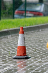 white-orange road cone on a rainy day