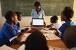 © Wavebreak Media - Young schoolboy with laptop at the front of class