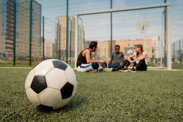 Poster - Soccer ball lying on the field or playground on background of players