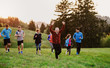 © Halfpoint - Large group of people cross country running in nature.