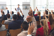 © wavebreak3 - Business people raising their hands at a business seminar