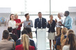 © wavebreak3 - Businessman standing at podium with colleagues and speaks in a business seminar
