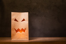 Paper Bag With Scary Face On Wooden Table