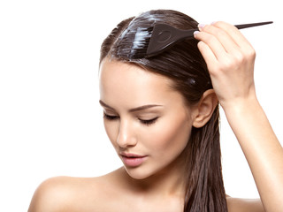 Young woman  coloring hair with brush