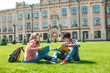© Oleksandr - Smiling African American student with glasses and with books and girl have fun chatting near college. Happy friends are talking on the background of the university.