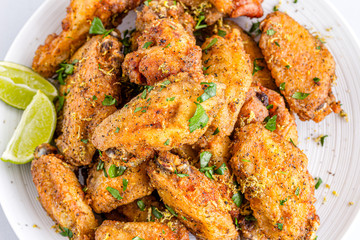 Fried Lemon Pepper Chicken Wings with Lemon Wedges.