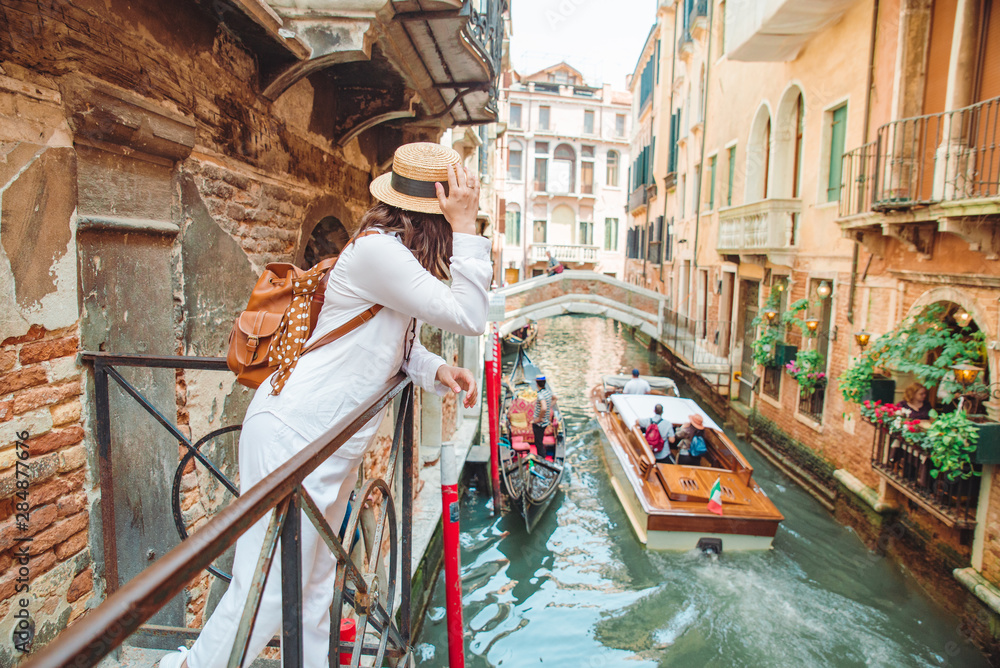 woman looking at canal with gandola - obrazy, fototapety, plakaty 