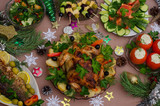 Fototapeta  - Christmas holiday table with chicken, fish, vegetables, canapes, decorated with coniferous branches, snowflakes