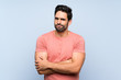 © luismolinero - Handsome young man in pink shirt over isolated blue background feeling upset