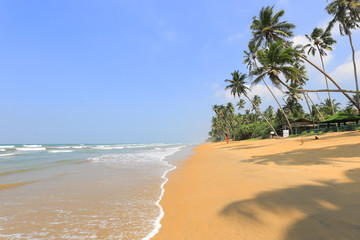 Beautiful tropical beach with sea wave and blue sky