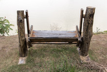 Rocking Bench On The Shore Of A Pond. Empty Wooden Swing On The Coast.