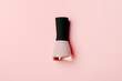 Nail polish bottle on stylish pink background. Pink fingernail varnish with black cap. Female cosmetics accessory. Manicure enamel, pedicure lacquer top view on nude backdrop. Minimalist promo banner