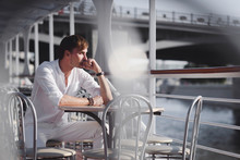 Pensive Man Wearing White Clothes Sitting On Excursion Boat At Sunlight Looking At Distance, Moscow, Russia
