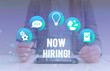 © Artur - Conceptual hand writing showing Now Hiring. Concept meaning finding evaluating working relationship with future employees Female human wear formal work suit presenting smart device