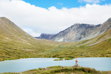 A Woman At A Lake On The Alpine Creek Trail, Clearwater Mountains, Alaska Range, Alaska, USA