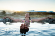 USA, California. A Woman Relaxes In Natural Hot Springs That Surface On The Eastern Side Of The Sierra Mountains Near The Town Of Bishop.