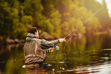 Fisherman Using Rod Fly Fishing In Mountain River