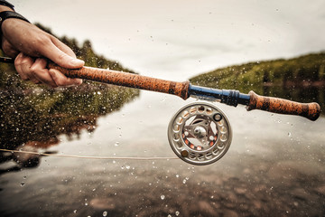 Wall Mural - Fisherman using rod fly fishing in mountain river