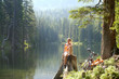© Westend61 - Young woman sitting on tree trunk and looking away