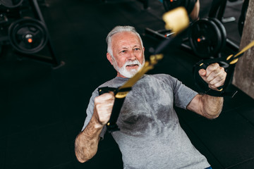 Senior man exercising at gym.