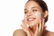 young woman applying moisturizing cream on her face. Skin care concept