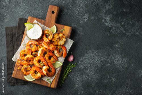 Fotomural Grilled shrimps or prawns served with lime, garlic and white sauce on a dark concrete background
