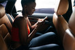 © Christin Nzobadila-Bela/PICHA - man using her phone in a car