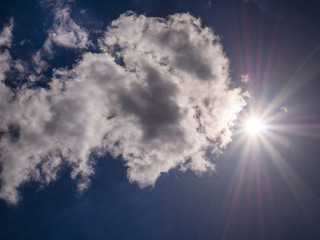 Wall Mural - Sun rays on dark blue sky with the approaching cloud