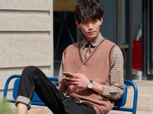 Portrait Of A Handsome Chinese Young Man With Korean Style Clothes Sitting And Looking Away With Mobile Phone In Hand, Male Fashion, Cool Asian Young Man Lifestyle.