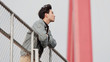 © atiger - Portrait of a handsome Chinese young man standing and looking away with arms leaning on rail in windy sunny day, enjoy the free wind.