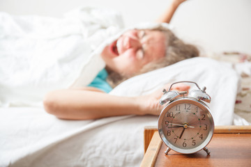 Young sleeping woman and alarm clock