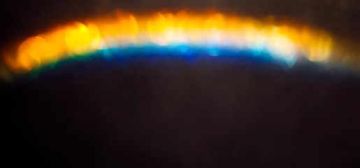 Wall Mural - iridescent holographic rainbow background. colorful lens flare bokeh texture on black