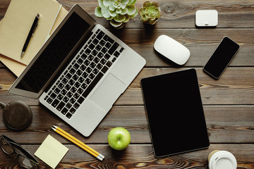 Office desk with laptop computer, supplies and green apple, top view