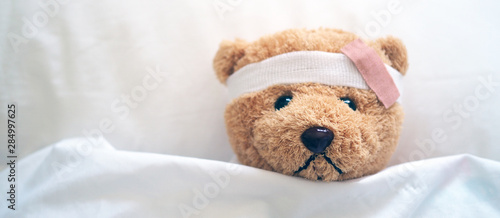 Cuadros en Lienzo Teddy bear and bandage. Injury concept