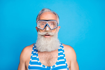 Sticker - Close up photo of impressed old man wearing striped bathing suit isolated over blue background