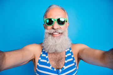 Sticker - Close photo of cheerful man making selfie with toothy smile wearing eyeglasses eyewear striped bathing suit isolated over blue background