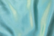 Pale blue colored Background of soft draped fabric. Beautiful satin silk textured cloth for making clothes and curtains. Textile background texture.